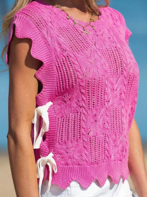 Chic openwork knit sweater vest in pink with cable knit details and adjustable white ties on the side.