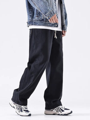 Men's black loose fit drawstring sweatpants with contrast stitching detail.