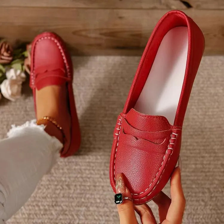 Red loafer flats with subtle stitching and a metallic finish.
