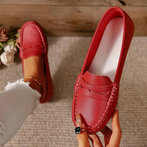 Red loafer flats with subtle stitching and a metallic finish.