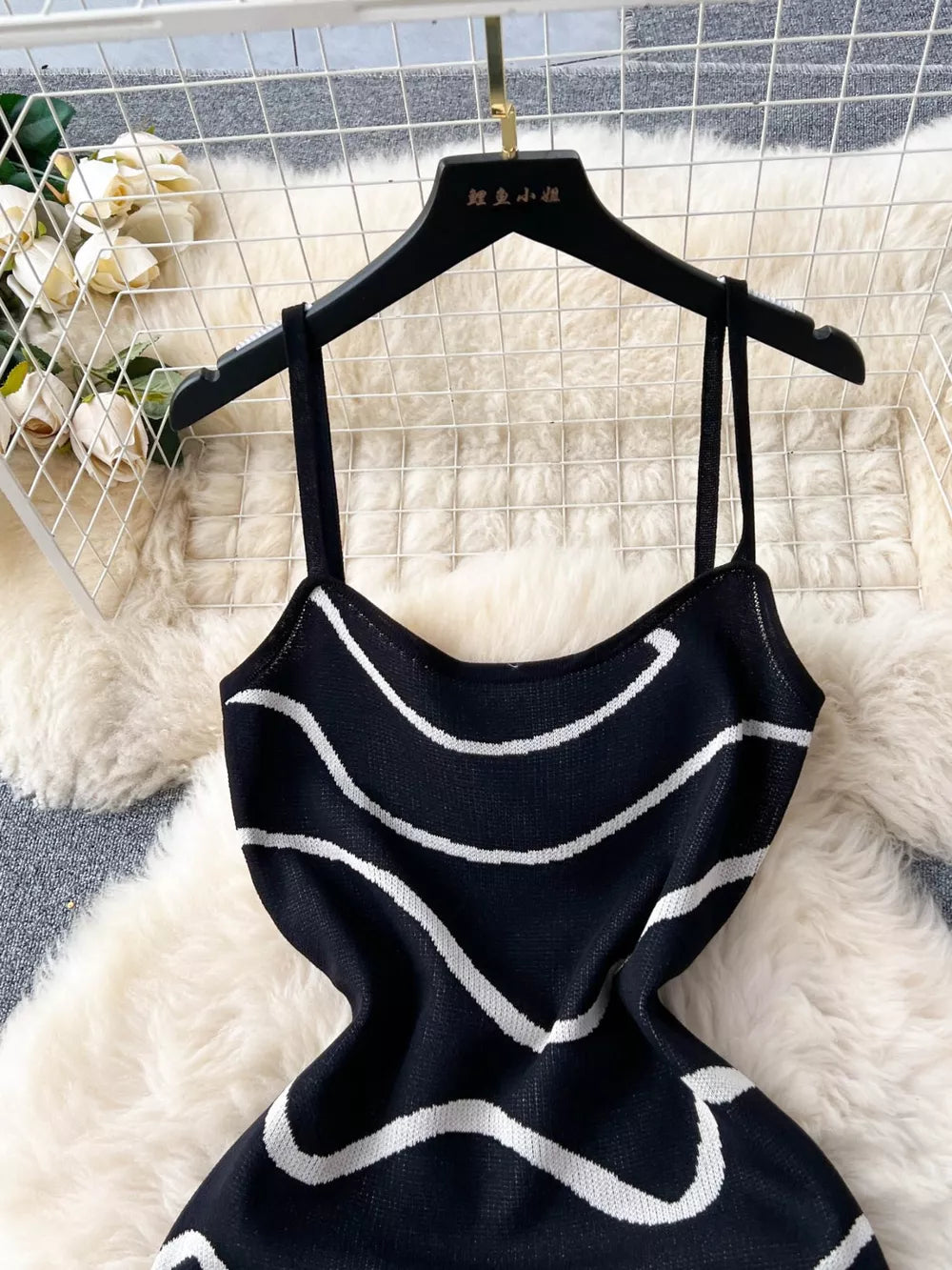 Black wavy knit midi dress with spaghetti straps and white wavy stripes.