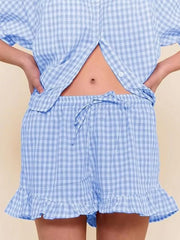 Blue gingham two-piece set with button-front top and ruffle-trim shorts.
