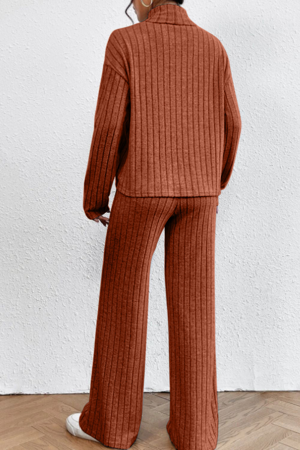 Ribbed knit turtleneck lounge set in rust, with long sleeves and wide-leg pants.