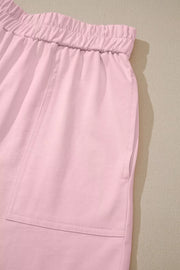 Blush pink pajama shorts with elastic waistband and patch pocket detail.