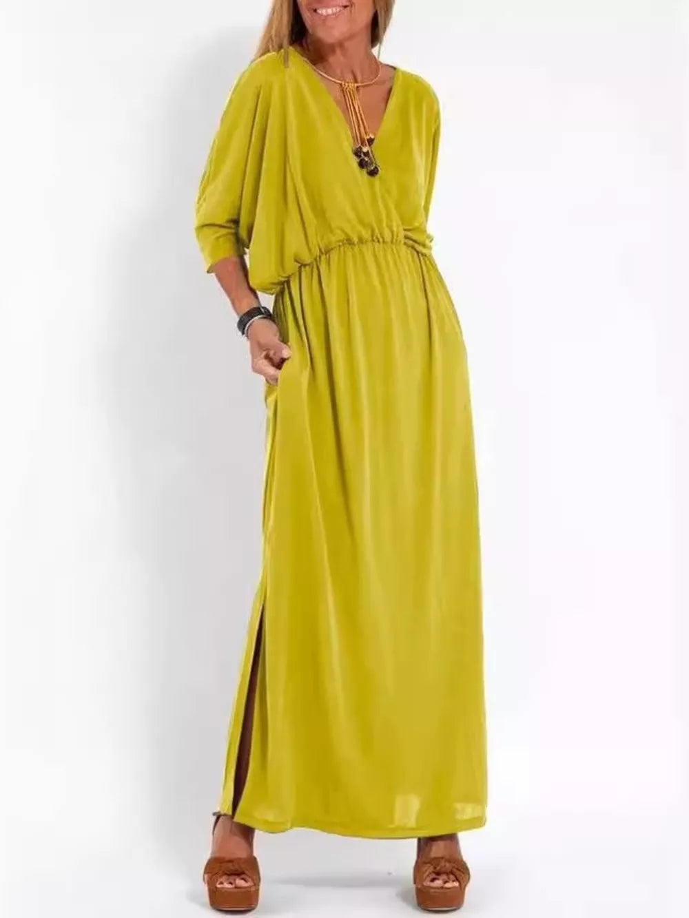 Yellow V-neck maxi dress with dolman sleeves, elastic waist, side slits, and pockets.