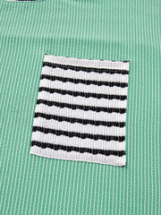 Turquoise long-sleeve top with twisted ribbing and a black and white striped pocket.