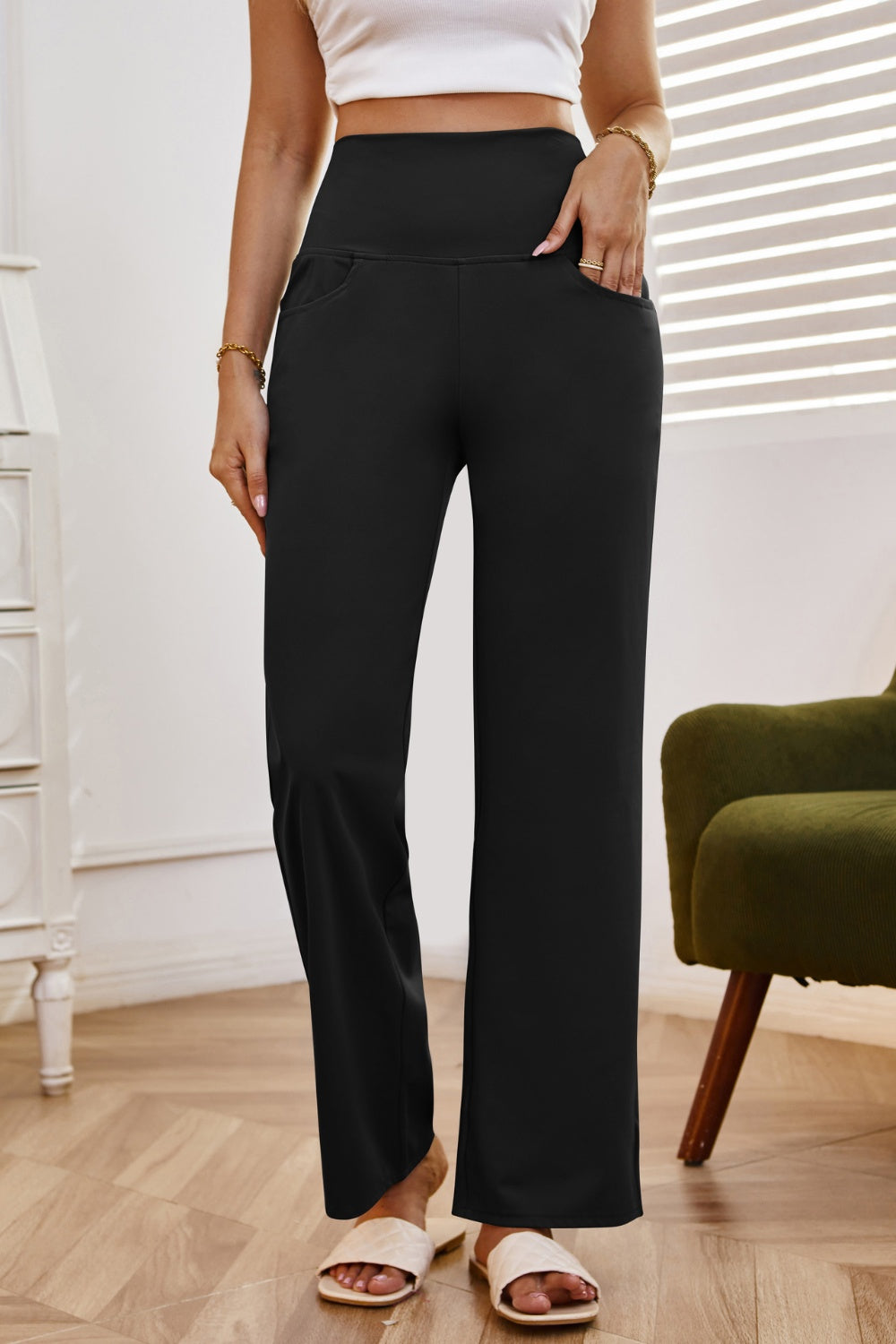 Black high-waisted flare leg trousers with pockets, styled casually.