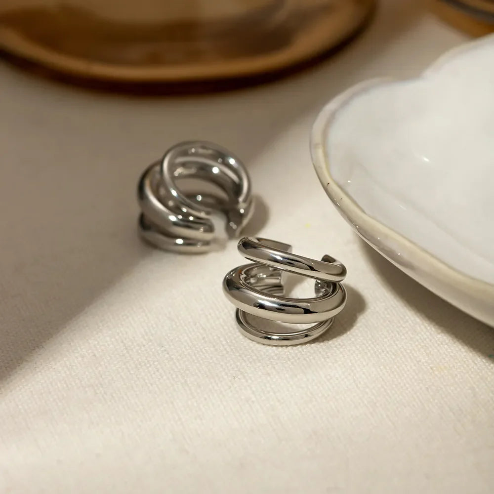Sculptural silver ear cuff and hoop earrings with layered design