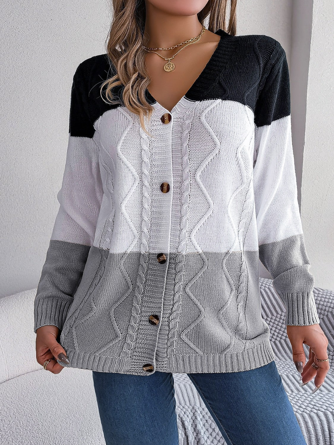 Colorblock cable knit cardigan with V-neck, buttons, and acrylic material.