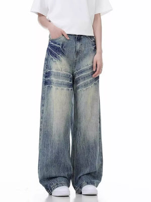 Distressed vintage wide-leg men's jeans in blue denim with faded wash and whiskering details.