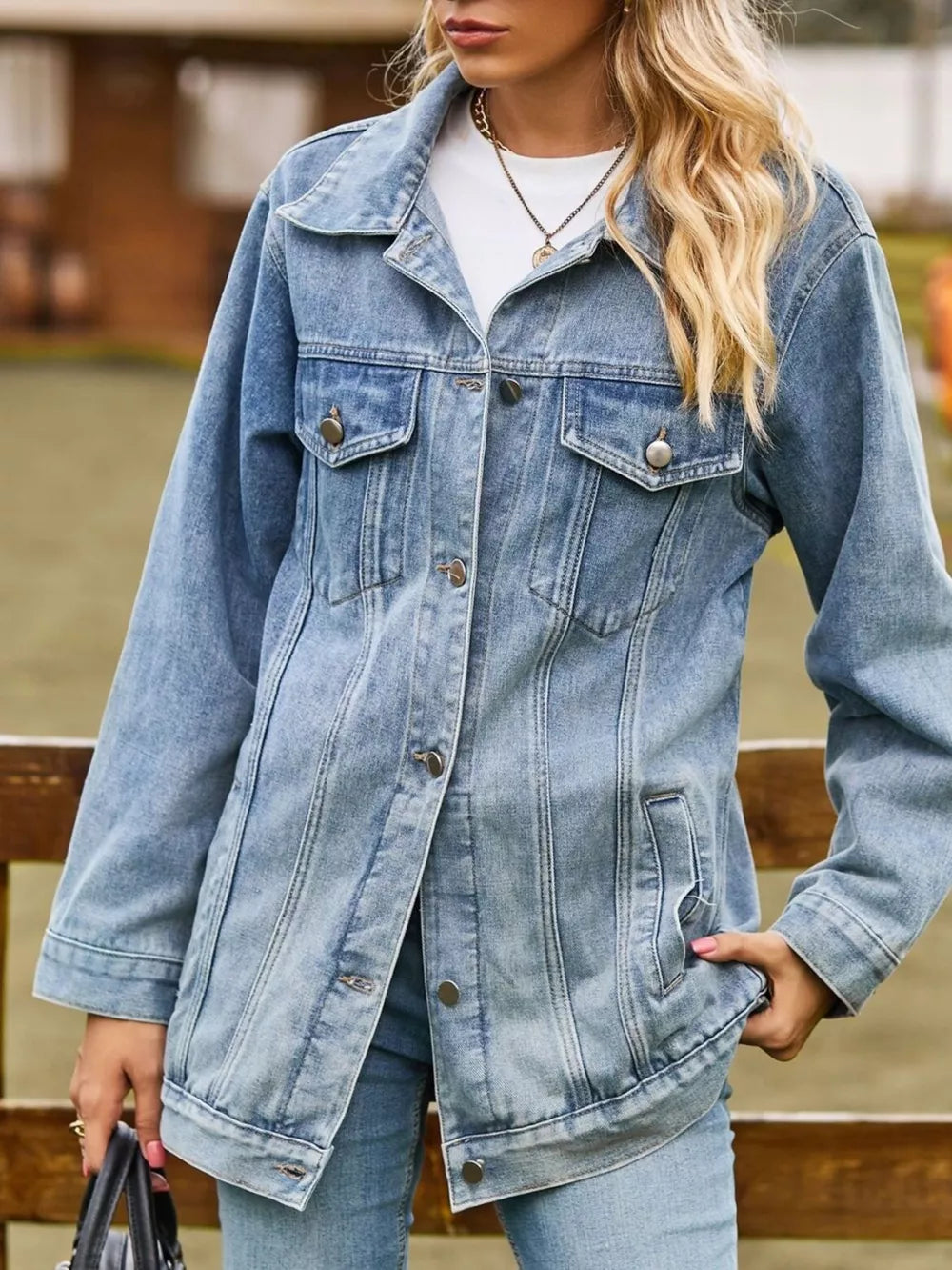 Relaxed fit medium wash denim trucker jacket with button front and chest pockets.