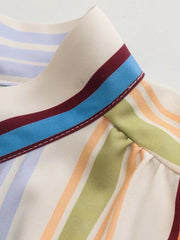 Prismatic stripe band collar blouse with multicolor stripes and blue, maroon trim detail.