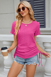 Hot pink perforated tee with gathered sides and tie detail, crew neck, short sleeves.
