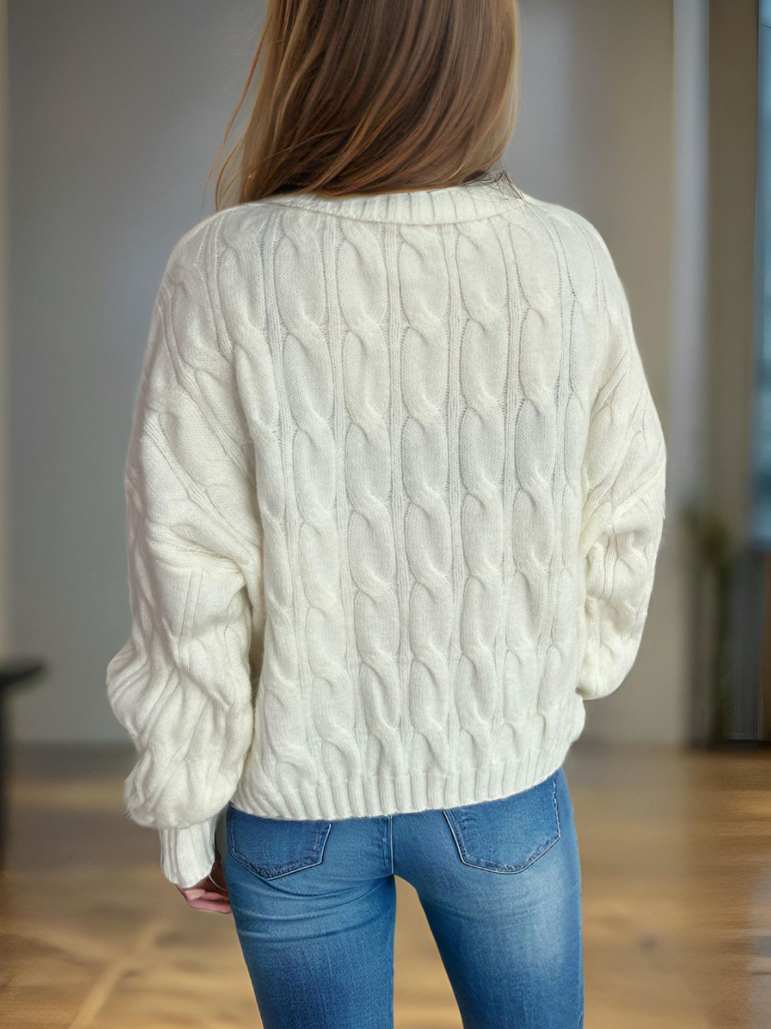 Oversized ivory cable knit turtleneck pullover sweater with textured knit detail.