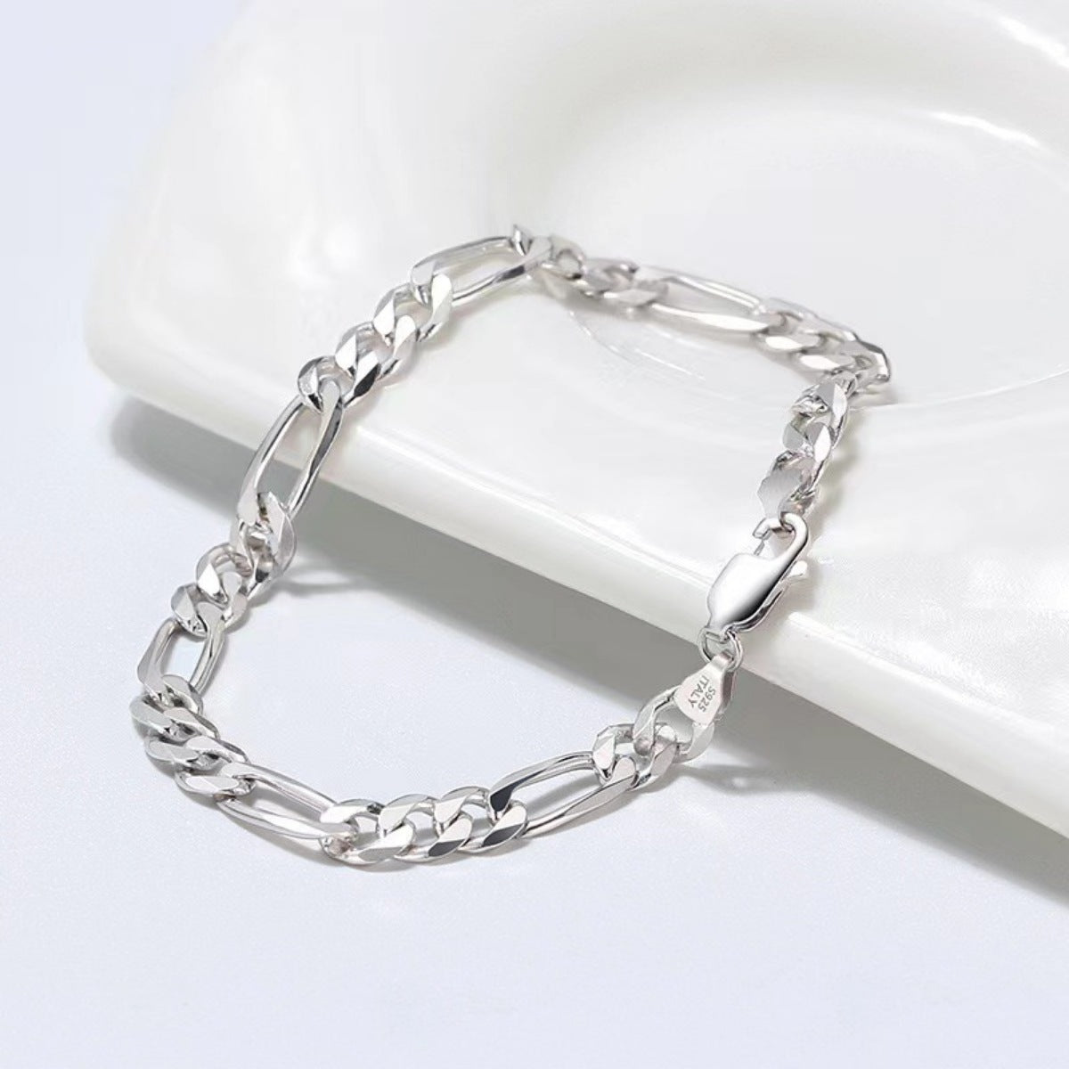 Sterling silver Figaro chain bracelet with alternating links and a lobster clasp.