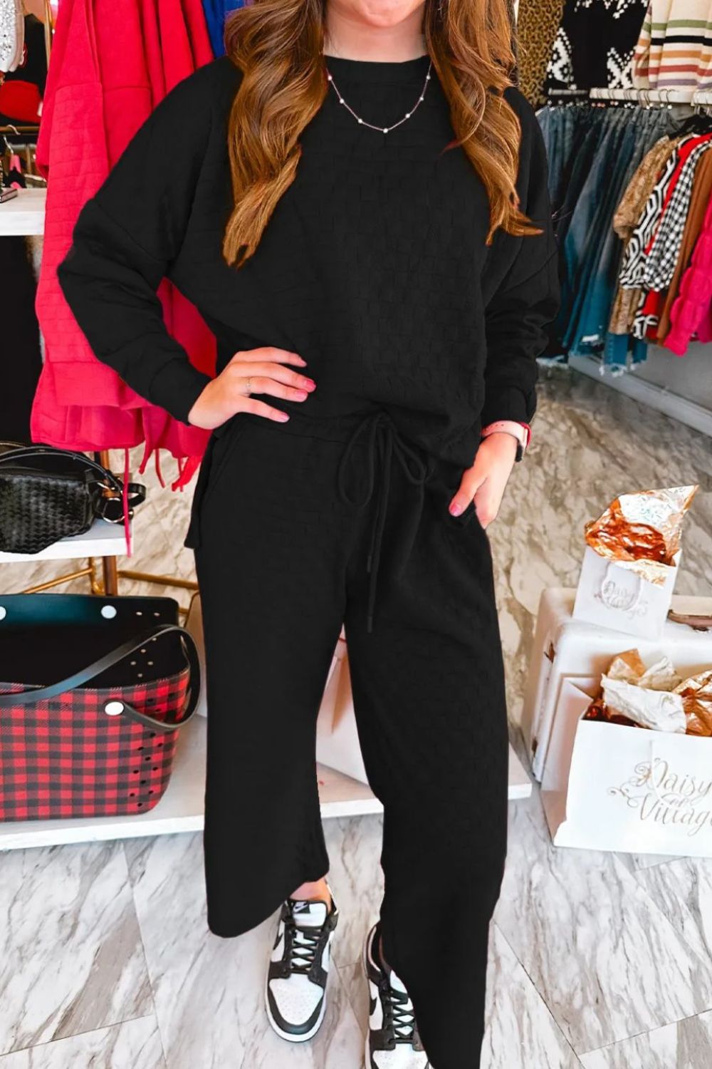 Black textured weave loungewear set with crew neck sweatshirt and drawstring pants.