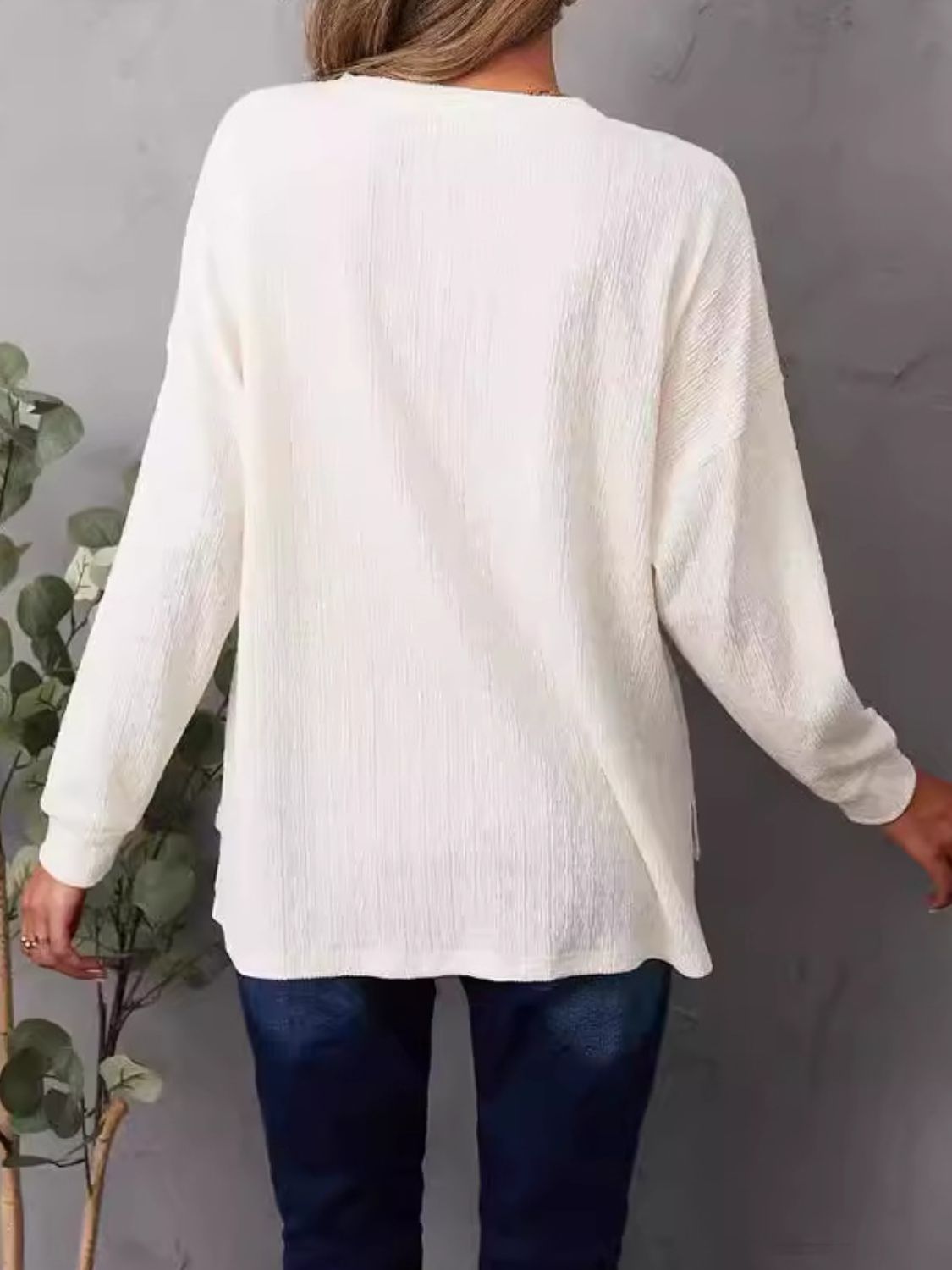 Ivory waffle knit henley shirt with long sleeves and side slits.