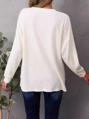 Ivory waffle knit henley shirt with long sleeves and side slits.