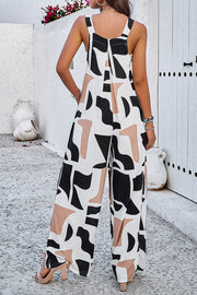 Abstract print wide leg jumpsuit with black, white, and tan shapes.