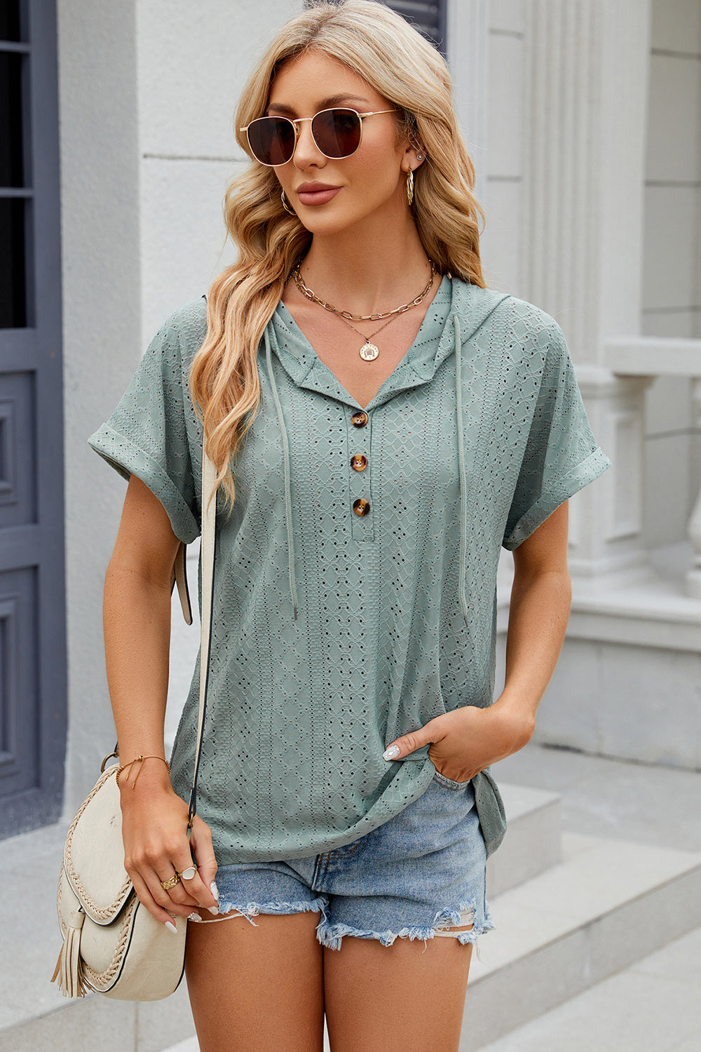 Perforated henley hooded tee in light green with short sleeves and a drawstring hood.