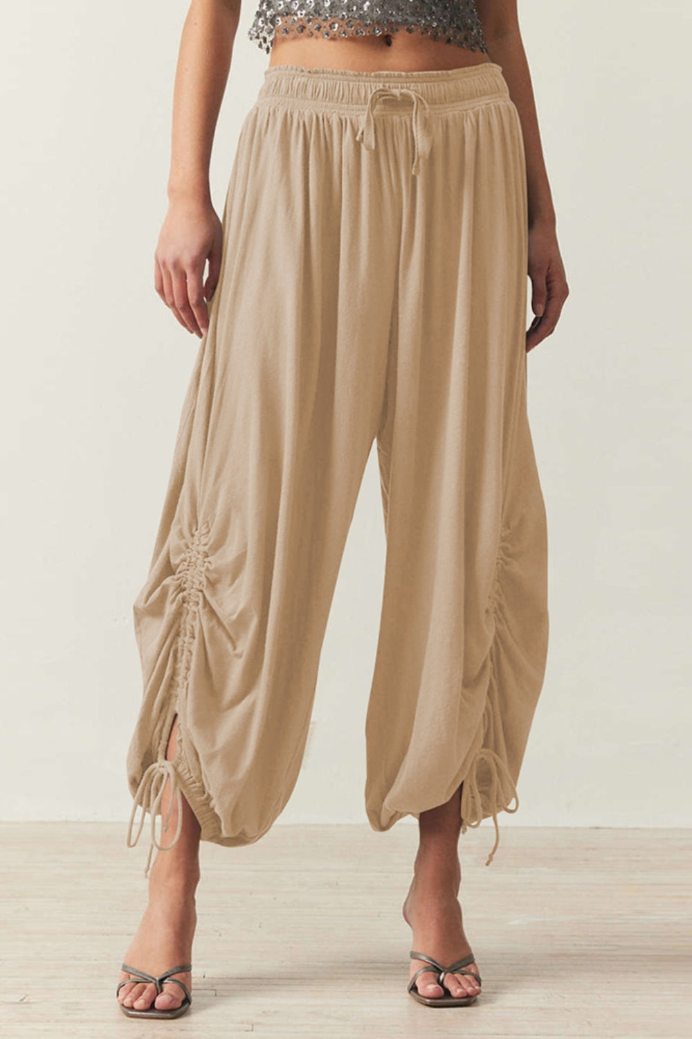 Tan gathered ankle-tie balloon trousers with drawstring waist and ruched detailing.