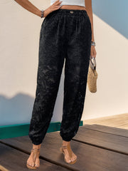Black lace jogger trousers with elastic waist and cuffed ankles.