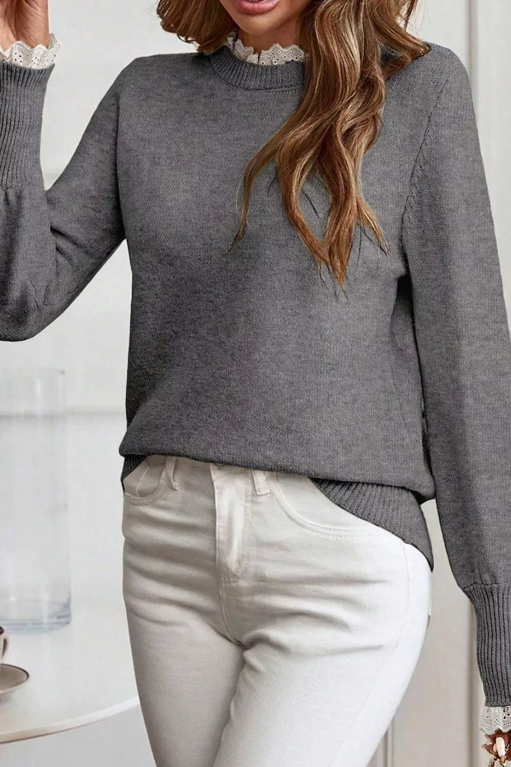 Dark gray knit sweater with mock neck and lace trim detail at collar and cuffs.