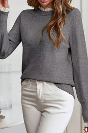 Dark gray knit sweater with mock neck and lace trim detail at collar and cuffs.