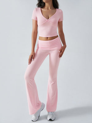 Blush pink loungewear set with ruched waistband flared pants and a ruched v-neck crop top.