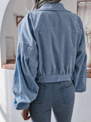 Blue corduroy cropped jacket with balloon sleeves and button detail.