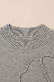 Gray knit top with a ribbed crewneck and drawstring detail.