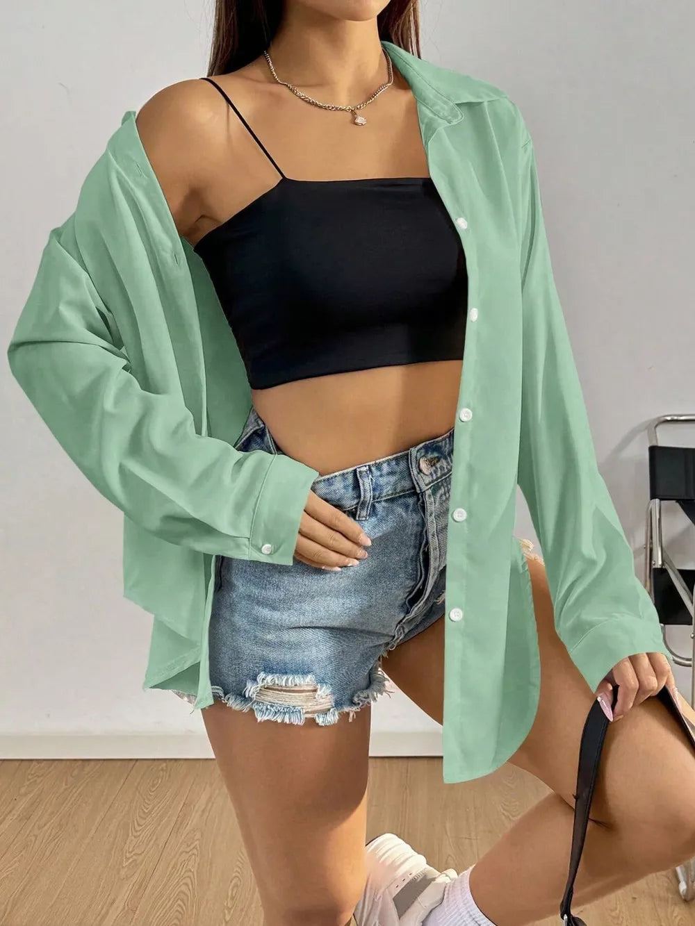 Gray green long sleeve button-up maternity shirt with classic collar, worn open over a black crop top.