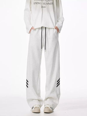 Light gray relaxed fit sweatpants with drawstring and black side stripes