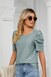 Teal perforated sleeve volume blouse with round neckline and puff sleeves.