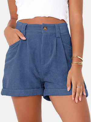 Dusty blue corduroy high-waist shorts with pleats and cuffed hems.