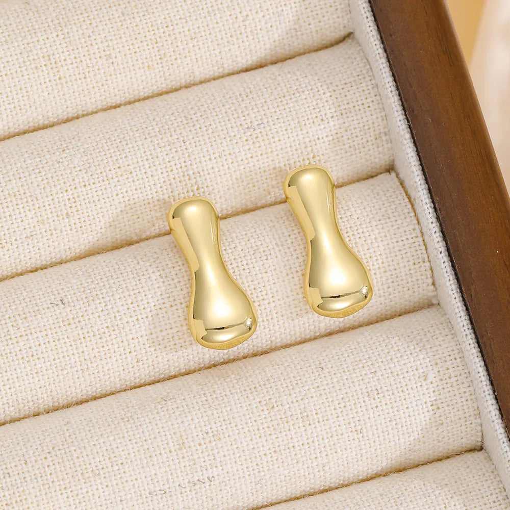 Gold sculptural stud earrings with a bubble-like shape.