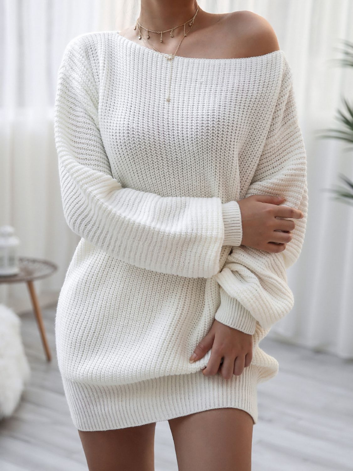 White acrylic sweater dress with off-shoulder neckline and balloon sleeves