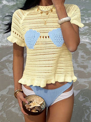 Yellow knit top with seashell cups and ruffled hem, styled with bikini bottoms.