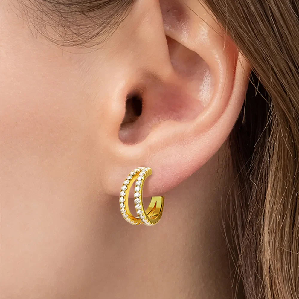 Gold double band hoop earrings with moissanite stones on a model's ear