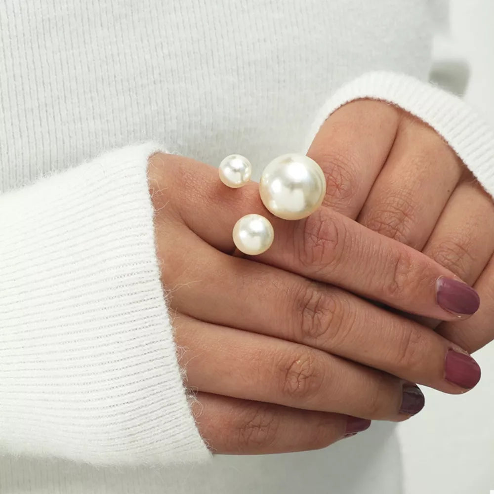 Elegant gold-plated open ring with three pearls, one large and two small.