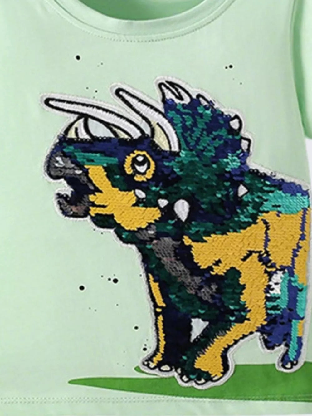 Light green cotton t-shirt with a sparkling sequin dinosaur graphic.