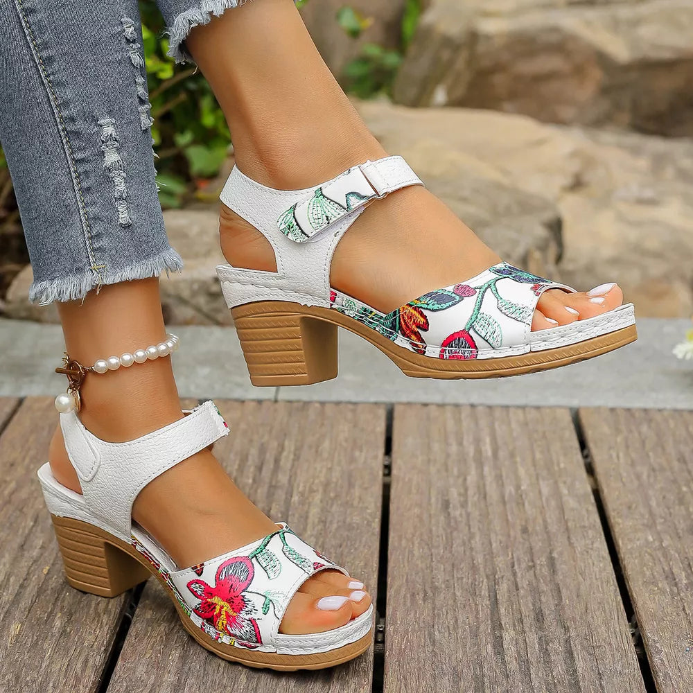 White floral open-toe sandals with adjustable strap and block heel.