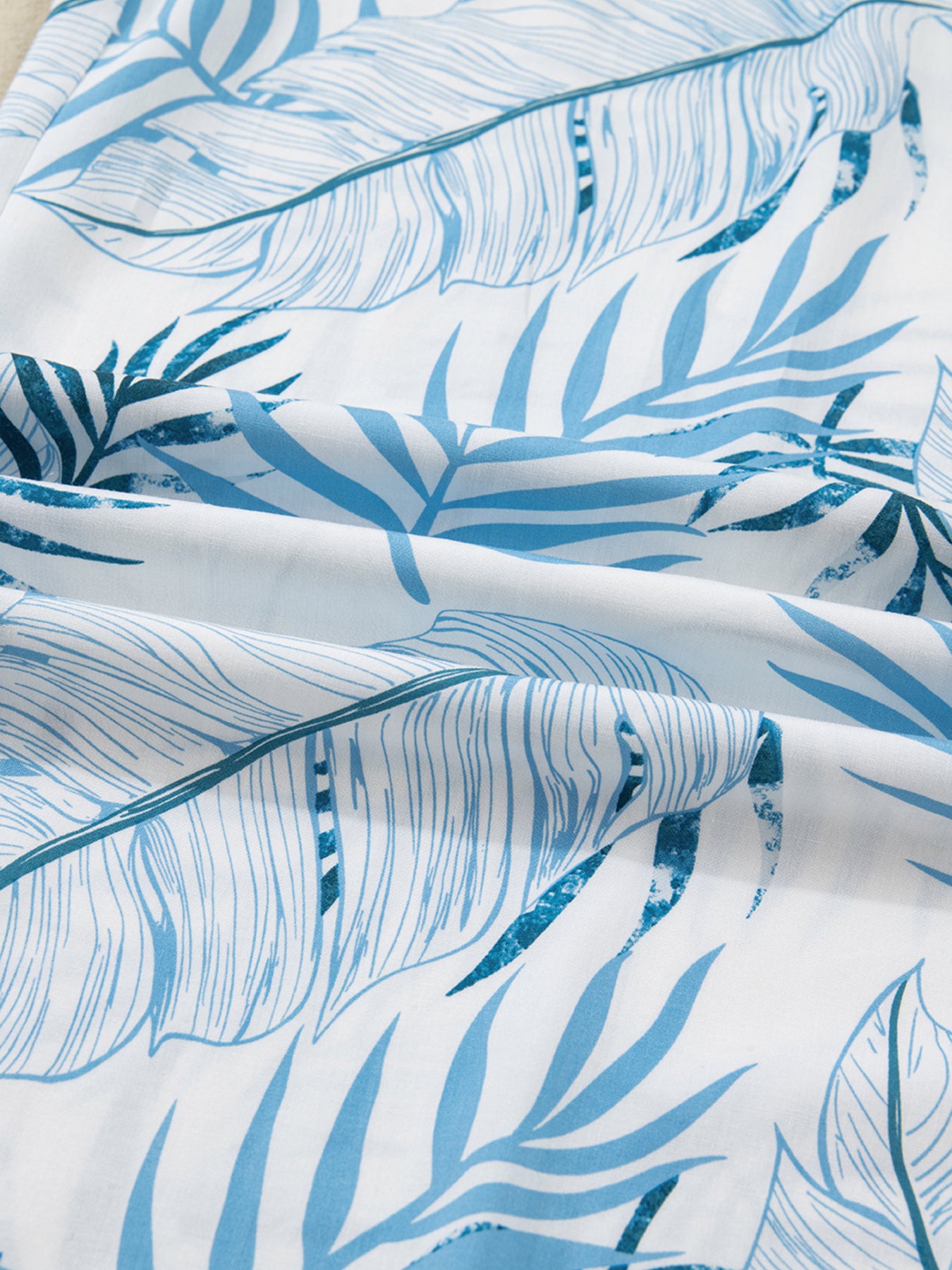 Tropical leaf print wide leg pants in blue and white cotton fabric.