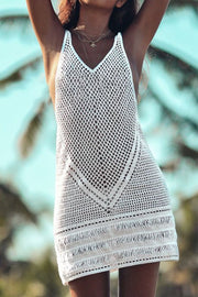 White crochet beach dress with V-neck and fringe hem.