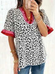 Leopard print blouse with ruffled neckline and sleeves in pink and red.