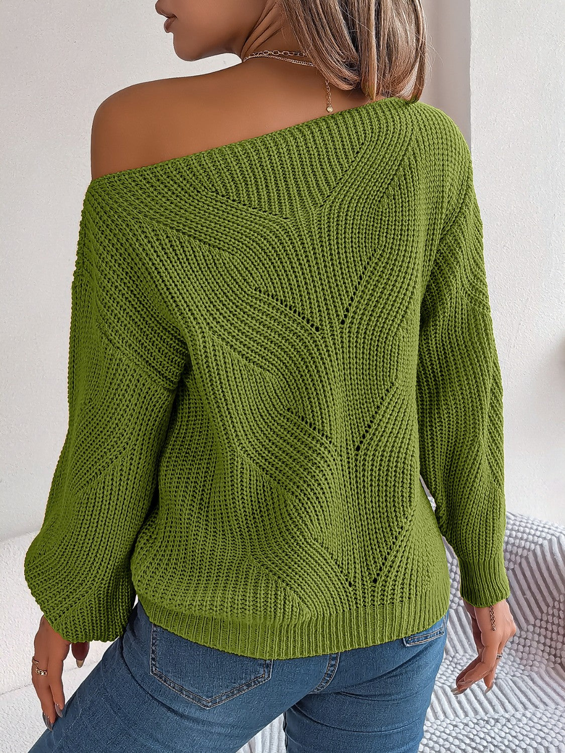 Moss green off-the-shoulder knit sweater with openwork detail and long sleeves.