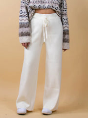 White ribbed knit palazzo trousers with drawstring waist, wide leg, and a cropped sweater.