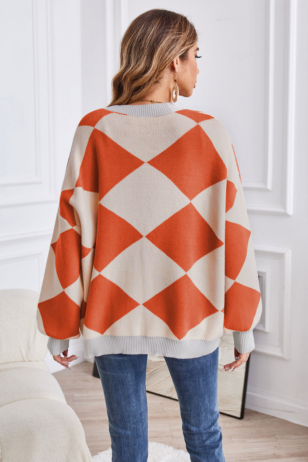 Diamond knit balloon sleeve cardigan in pumpkin and cream acrylic with grey trim.