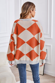 Diamond knit balloon sleeve cardigan in pumpkin and cream acrylic with grey trim.