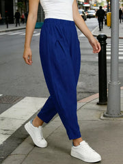 Royal blue harem pants with pockets and elastic waist, styled with white sneakers.